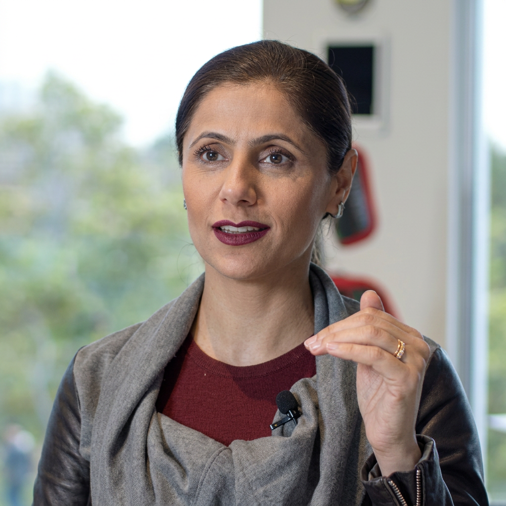 Malkia Junaid speaking with a blurred indoor background