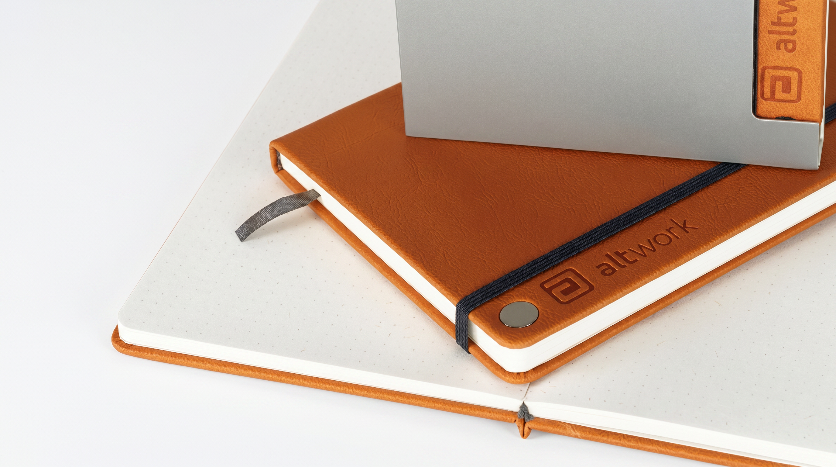 Orange Altwork notebooks on a white surface, featuring the 'Altwork' brand.